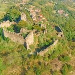 Vue aérienne du château de Lordat, forteresse médiévale en ruine entourée de forêts verdoyantes.